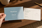 Hand holding a personalized Madeline and Owen save-the-date postcard beside its addressable mailing back